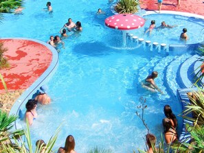 A large outdoor swimming pool with multiple lanes and a central water feature.