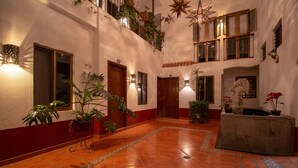 Un hall amplio con suelo de baldosas, varias puertas y plantas en macetas.