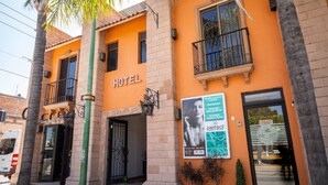 Un hotel con un letrero 'HOTEL', un balcón y un letrero 'CERRADO'.