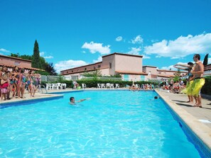 A swimming pool with people around it.