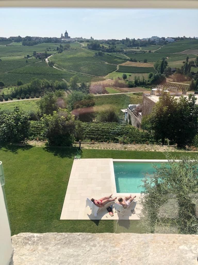 A poolside view with a clear view of the surrounding landscape, including vineyards and distant buildings.