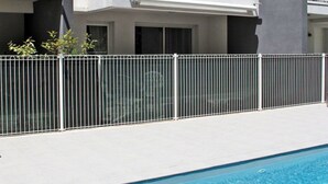 Un edificio moderno con piscina, caratterizzato da un esterno bianco, una sezione grigia e un tendone giallo.