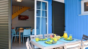 An outdoor dining area with a table set for two, featuring a fruit basket, glasses of orange juice, and a bottle of water. - Beautiful apartment in villa for 6 guests with pool, A/C, WIFI, terrace and pets allowed (Sète)