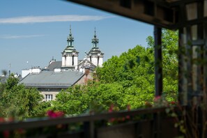 A view of a building with two prominent towers, surrounded by lush greenery. - 2bdr Kazimierz Apartment, great terrace, aircon (Kraków)