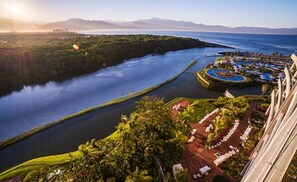 Relax amidst serene river and mountain views, with a tranquil lawn area and comfortable lounge seating.
