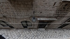 Un bâtiment en pierre doté de fenêtres en arc de cercle et d’un sol carrelé.
