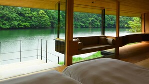 A modern room with a large window overlooking a lake and forest. - Kohanyu (Kami)