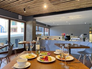 Een modern restaurant met een houten plafond, grote ramen en een bar.