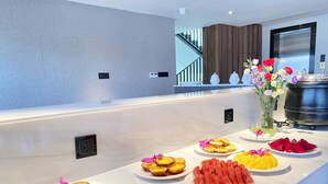 A buffet table with various food items and a vase of flowers. - Yunfan Hotel (Phnom Penh)