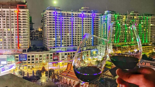 A nighttime cityscape with illuminated buildings and a model of a traditional structure. - Yunfan Hotel (Phnom Penh)