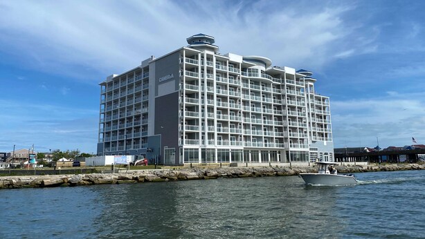 A multi-story hotel with balconies, located near a waterfront. - Cambria Hotel Ocean City - Bayfront (Ocean City)