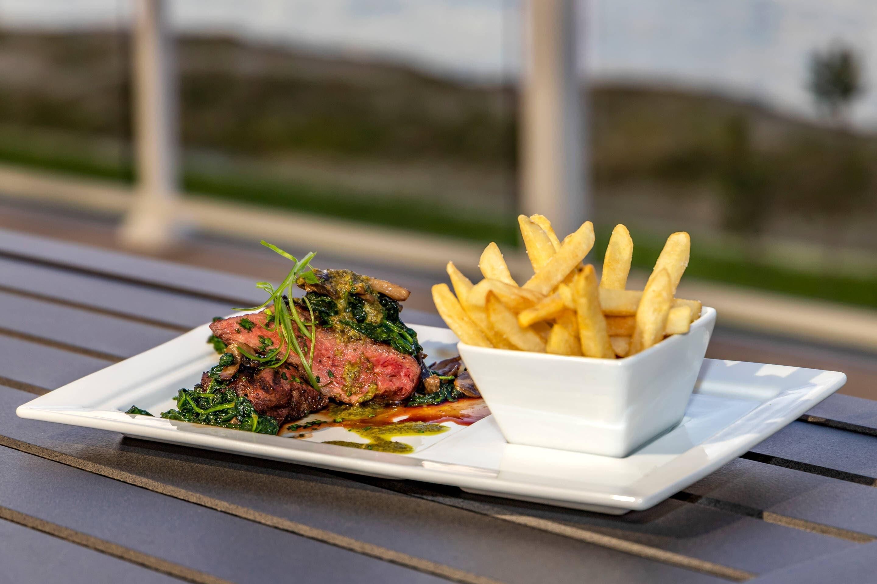 A plate of steak with fries on a table.