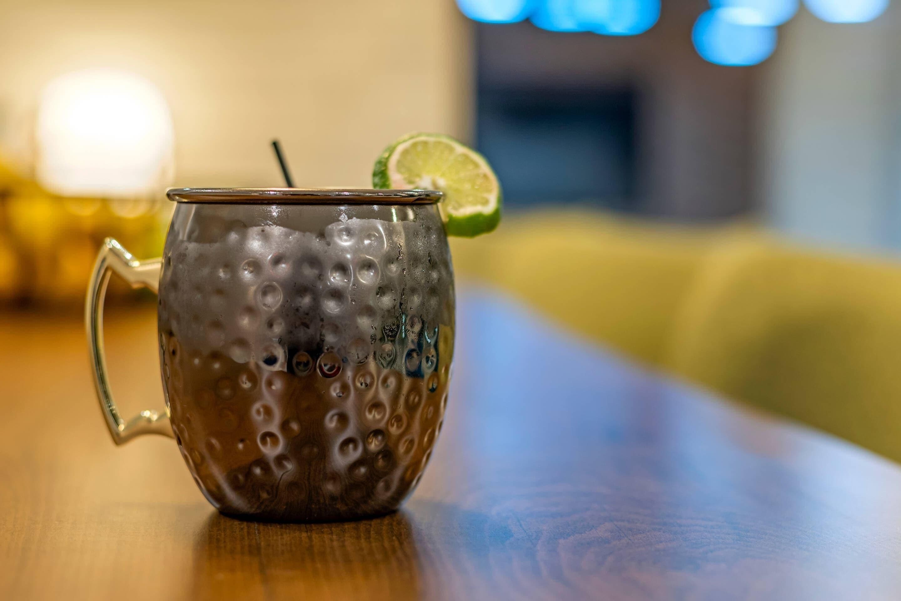 A textured glass mug with a handle on a wooden surface.