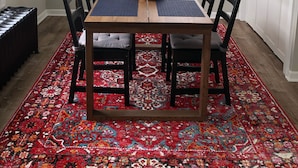 A dining area with a wooden table, four chairs, a red patterned rug, a potted plant, a mirror, and a window with blinds. - Fresh space near Mayo Clinic and downtown (Rochester)