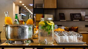 A bar area with a metal bucket holding bottles and a large glass pitcher with a lemon slice and mint leaves.
