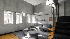 A modern interior with a staircase, grey walls, and a wooden floor.