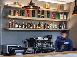 A bar area with shelves of liquor bottles, a coffee machine, and a counter. - ibis Chia (Chia)