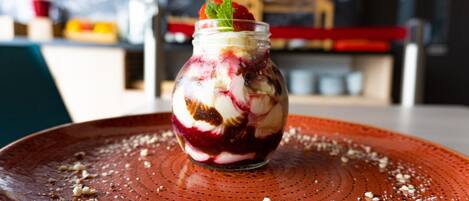 A dessert in a jar on a plate with a textured surface.
