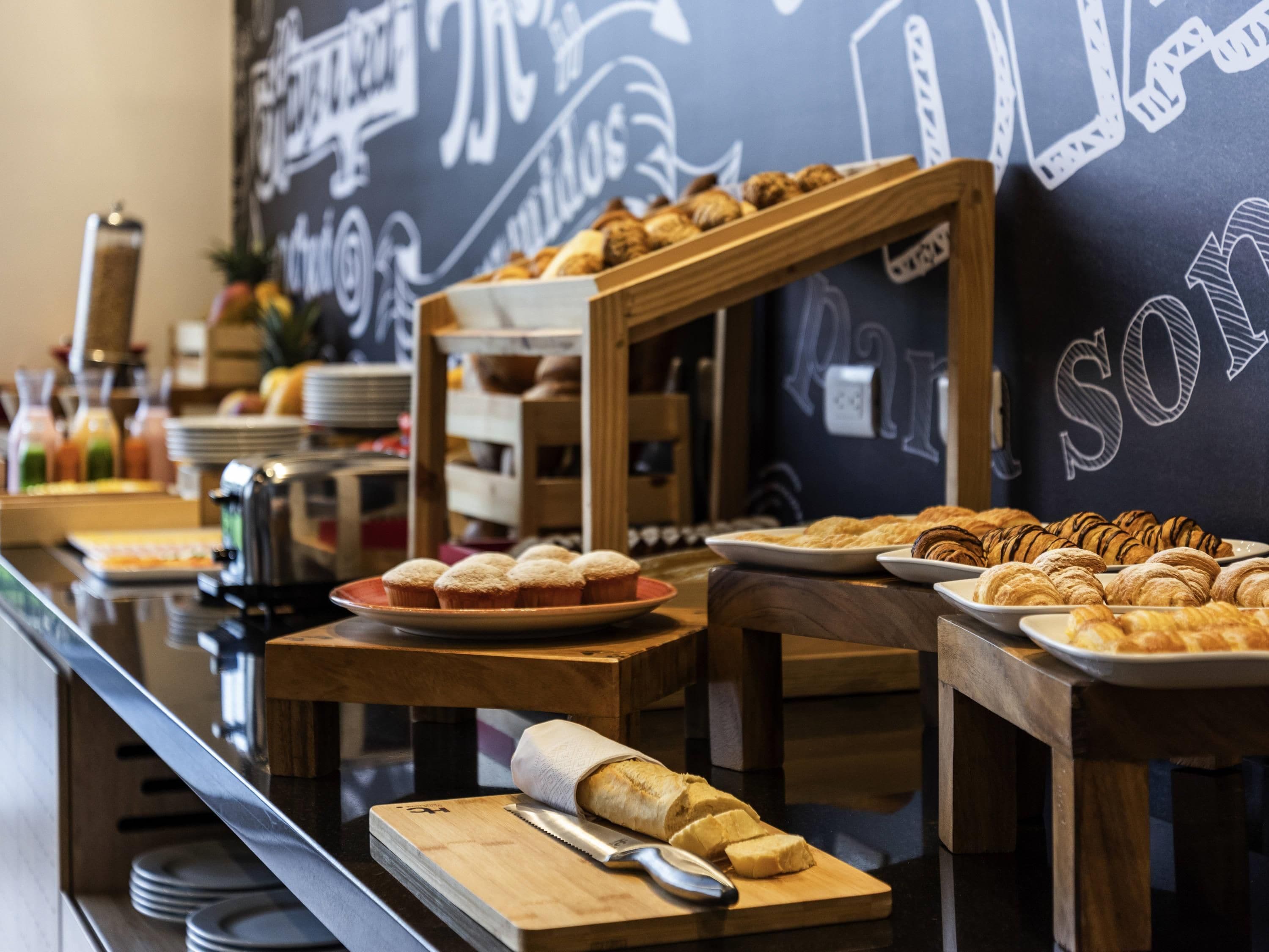 Un buffet proposant diverses pâtisseries et un tableau noir affichant les options du menu.