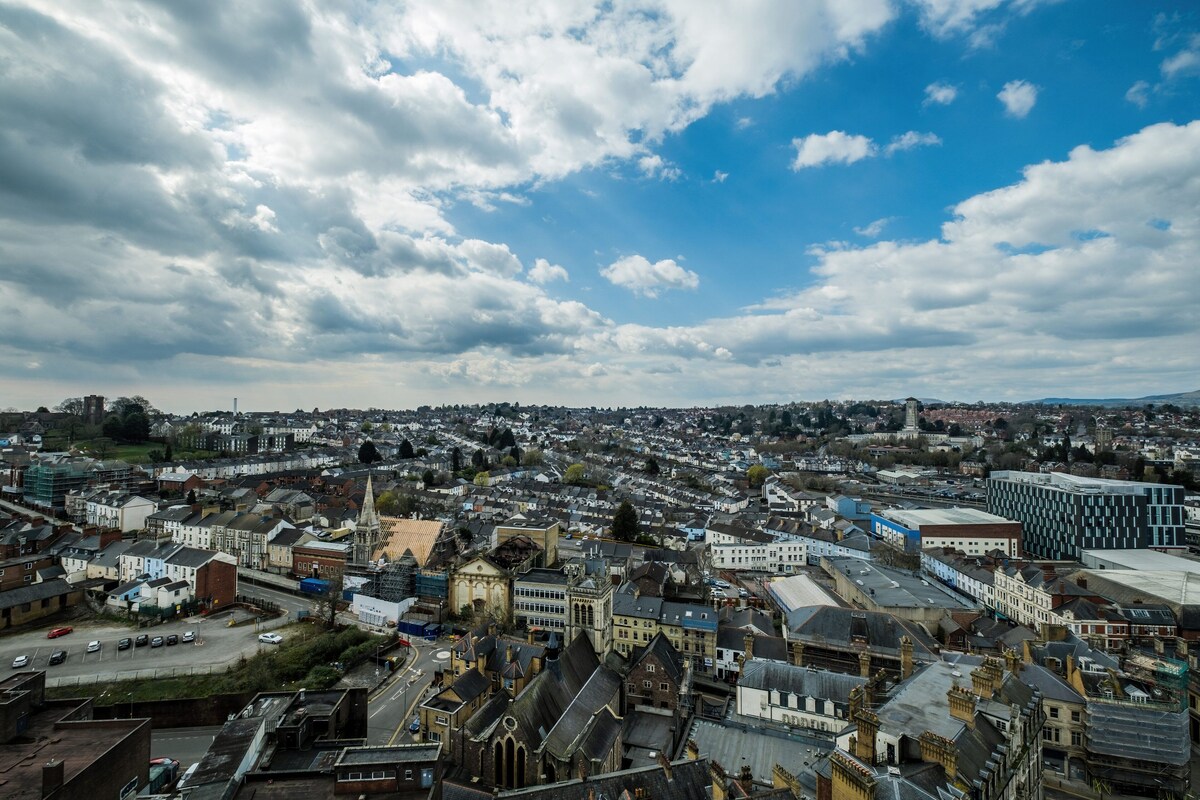 A cityscape with a mix of historic and modern buildings, a prominent church, and a clear blue sky.