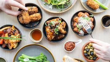Una mesa con diversos platos, incluyendo frituras, ensaladas y pan.