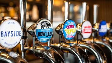 A row of beer taps with labels indicating different beer brands and types.
