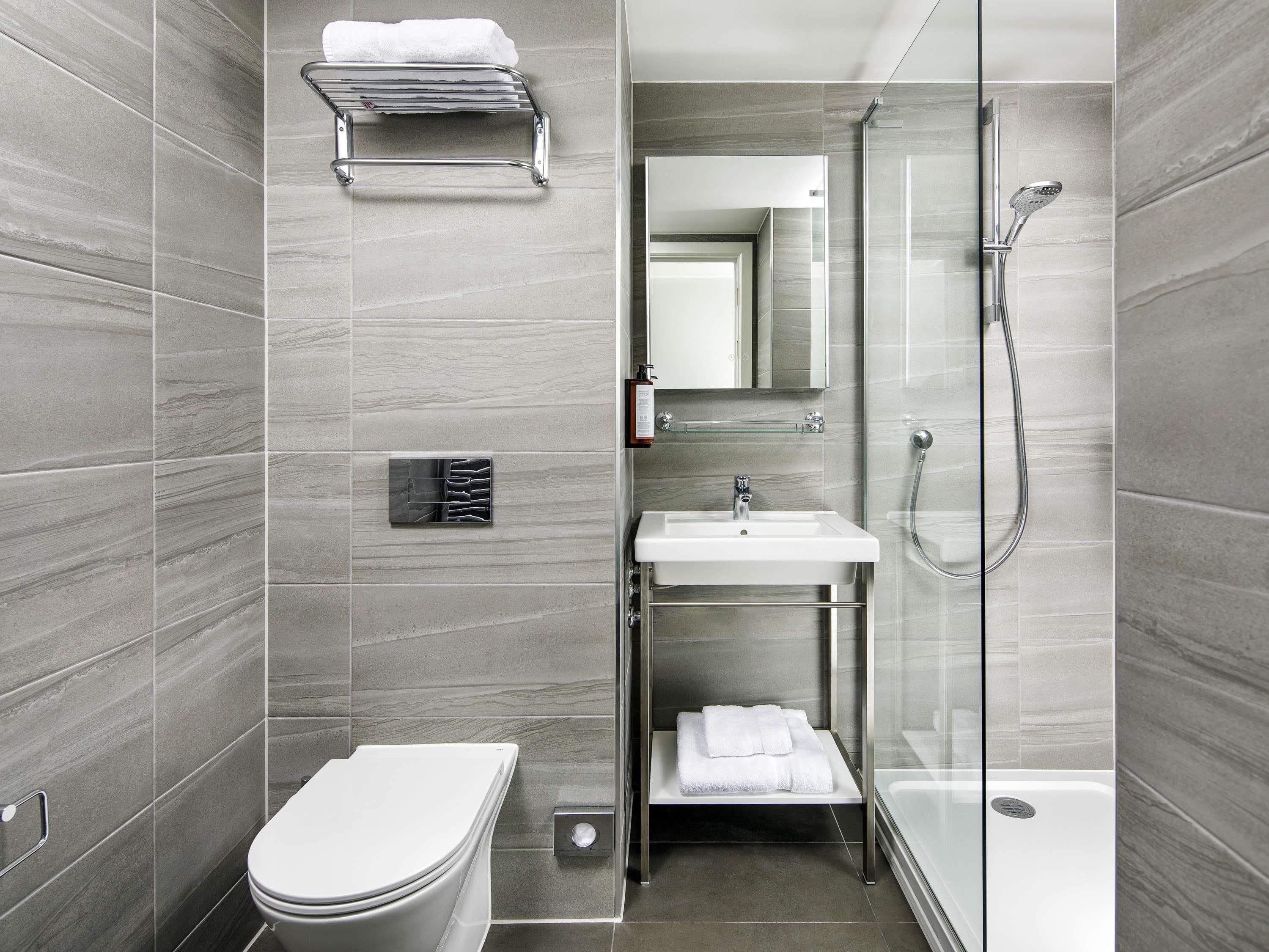 A modern bathroom with a toilet, sink, and shower area.
