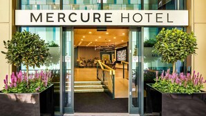 The entrance to Mercure Hotel with a modern design, automatic doors, and a staircase leading inside. - Mercure Newport Hotel (Newport)
