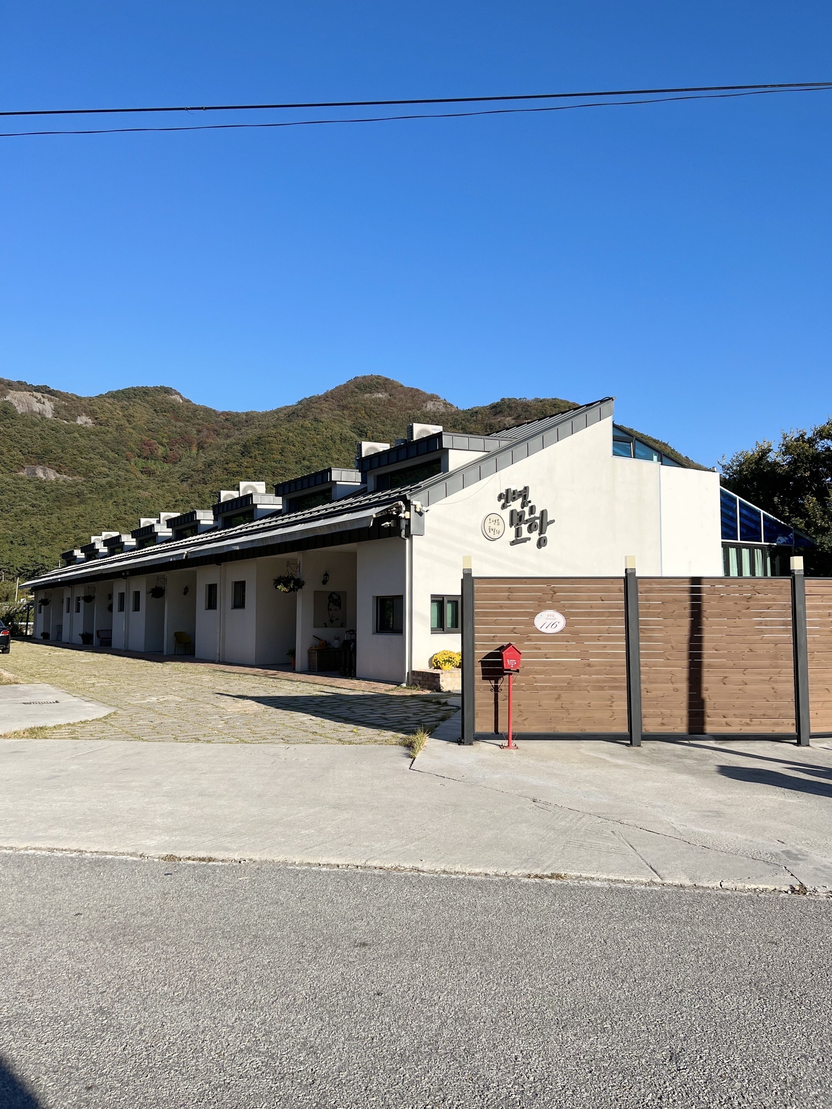 Un bâtiment moderne doté d’un toit plat, d’une grande entrée et d’une clôture en bois.