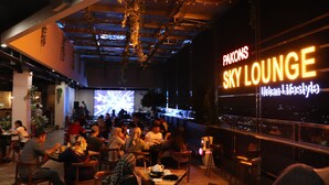 Um restaurante com vista para a cidade, chamado 'PAKONS SKY LOUNGE Urban Lifestyle'.
