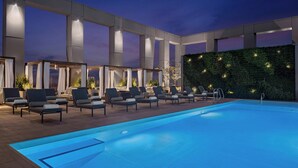 A rooftop pool area with lounge chairs and a large wall of greenery. - The Joseph, a Luxury Collection Hotel, Nashville (Nashville)