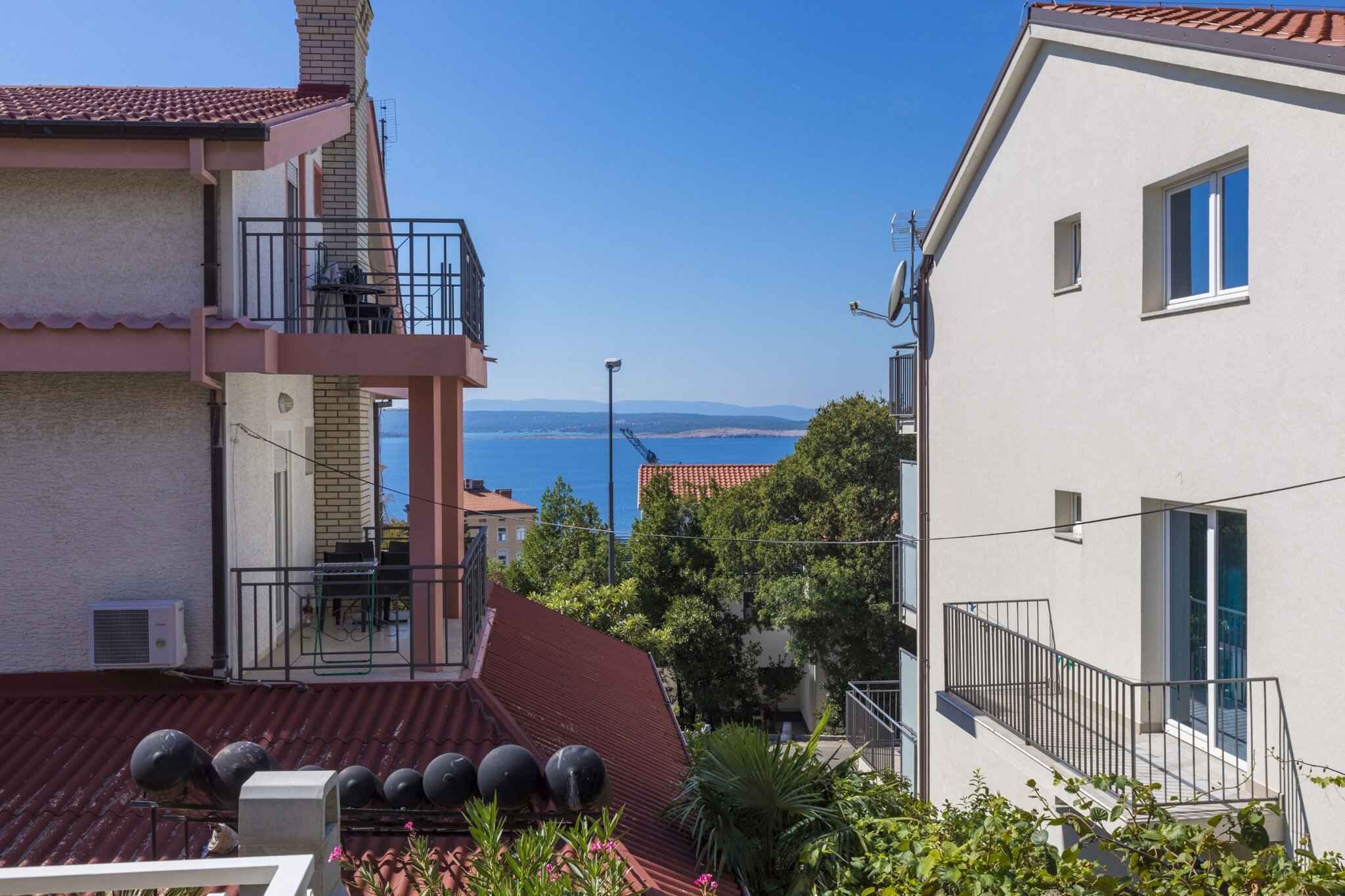Un immeuble résidentiel doté d’un balcon offrant une vue sur la côte.