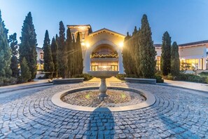 A hotel with a central fountain, surrounded by cobblestone pathways and tall trees. - Bright 2 Bedroom Villa with Private Pool - LO4LT (Torre-Pacheco)