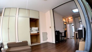 A room with a wooden floor, a sofa, a desk with a chair, and a wardrobe. - Big Stone Tsukuda 202 (Aomori)
