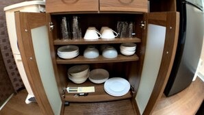 A compact kitchen with wooden cabinetry, a microwave, and a refrigerator. - Big Stone Tsukuda 202 (Aomori)