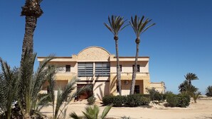 A modern building with a flat roof, large windows, and a central entrance. - Bella Djerba (Sidi Salem)