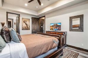 A bedroom with a bed, a dresser, a television, and artwork on the walls. - 4098 Coral Ridge, The 19th Hole in Coral Ridge, near golf course, firepit, heated pool, SLP 12 (Washington)