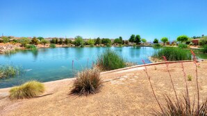 A serene lake with clear water, surrounded by dry grass and sparse vegetation. - 4098 Coral Ridge, The 19th Hole in Coral Ridge, near golf course, firepit, heated pool, SLP 12 (Washington)