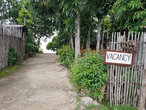 A pathway leading to a wooden gate with a 'VACANCY' sign. - Diamond De Siquijor Beach House (Siquijor)