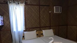 Una habitación con una cama, televisión, cortina y aire acondicionado.