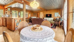 A wooden interior with a dining table, chairs, a sofa, and a television. - Spacious one bedroom log cabin with views for miles! Only one mile from the Wimb (Wimberley)