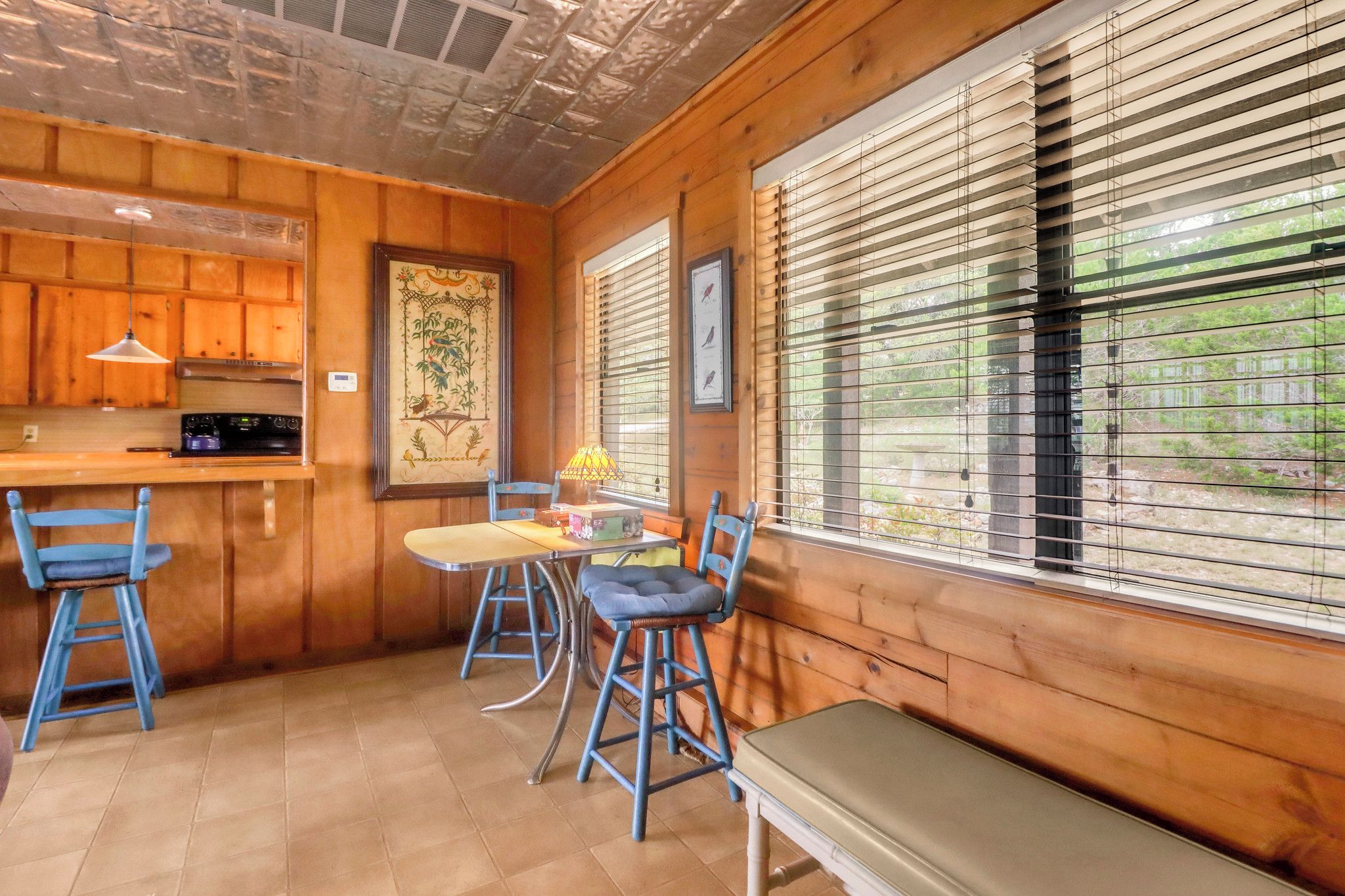 A wooden interior with a kitchen, dining area, and large windows.