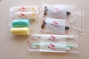 A set of packaged personal care items including body sponges and toothbrushes, arranged on a surface.