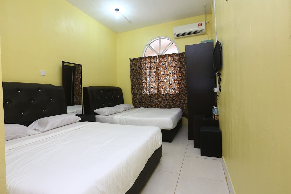 Une chambre d’hôtel avec deux lits, une armoire, un téléviseur et un climatiseur mural.