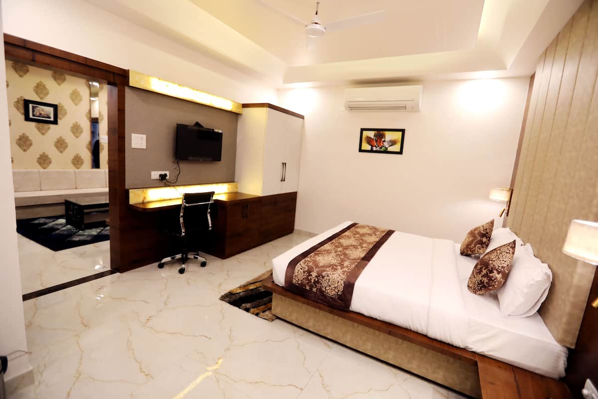 A modern hotel room with a bed, desk, and wardrobe.