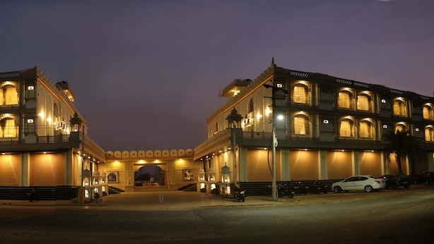 A large, illuminated building with multiple balconies and arched windows, likely a hotel or public building.