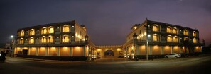 A large, illuminated building with multiple balconies and arched windows, likely a hotel or public building. - Hotel Neva Ji Palace (Kota)
