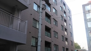 A multi-story building with a parking area in front.