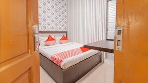 Un dormitorio con cama, una mesita de noche y una ventana con persianas.