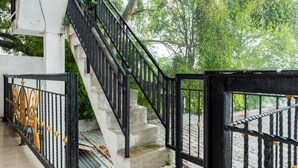 A staircase with black railings and a white wall. - OYO 2169  Anugrah Bromo Homestay (Wonokitri)
